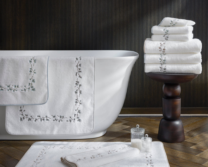 Matouk Jasmine Giza white long staple cotton luxury bath towels and tub mat with elegant jasmine stem embroidery finished with a complementing tape edge